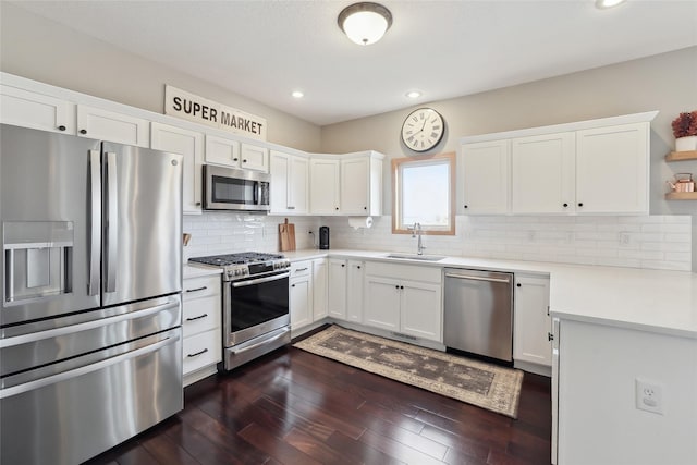 kitchen with stainless steel appliances, white cabinets, light countertops, and a sink