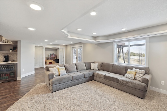 living area featuring wine cooler, recessed lighting, dark wood-style flooring, baseboards, and a dry bar