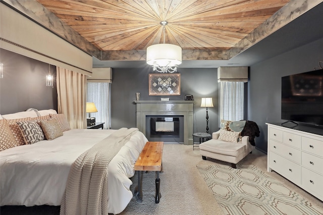 bedroom featuring a notable chandelier, wooden ceiling, a glass covered fireplace, and light colored carpet