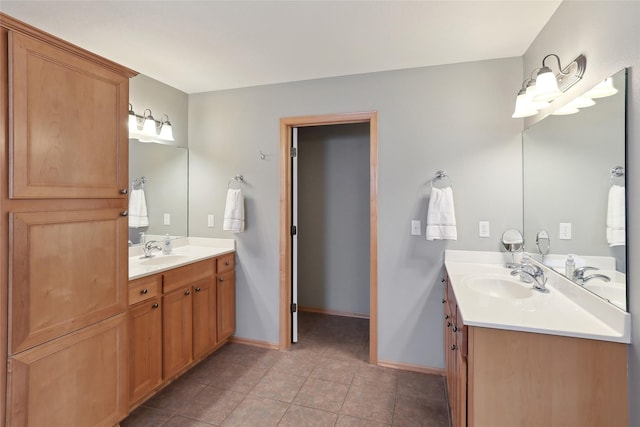 bathroom featuring baseboards, a sink, and tile patterned floors