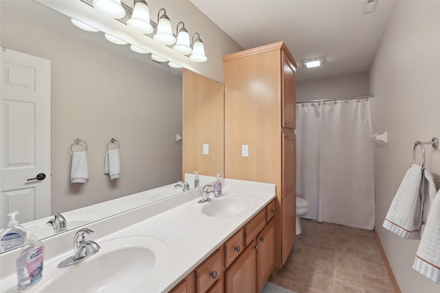 full bath featuring toilet, double vanity, and a sink