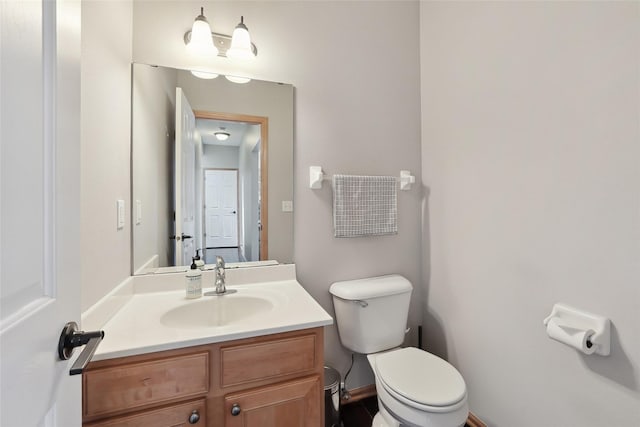 half bathroom with vanity and toilet