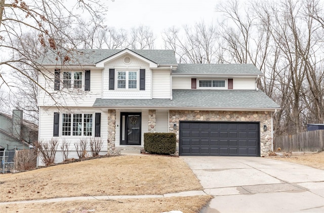 traditional-style house with driveway, a garage, a shingled roof, stone siding, and fence