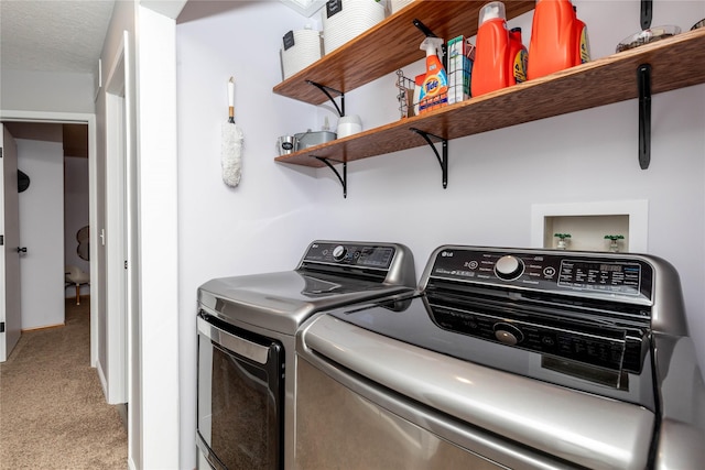 laundry area with laundry area, washing machine and dryer, and light colored carpet