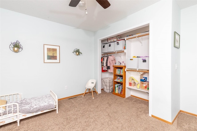 carpeted bedroom with a ceiling fan, a closet, and baseboards