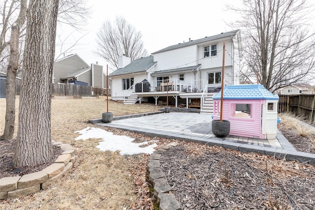 back of property with an outbuilding, a fenced backyard, a patio, and a wooden deck