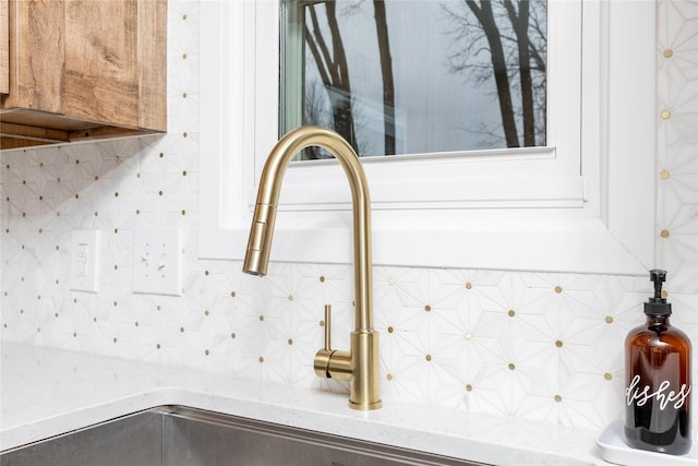 interior details with light stone countertops and decorative backsplash