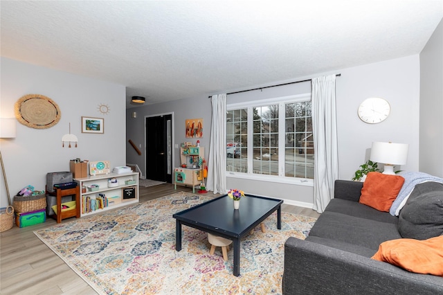 living room with a textured ceiling, stairway, and wood finished floors