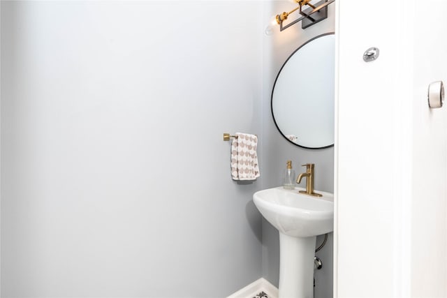 bathroom featuring baseboards and a sink