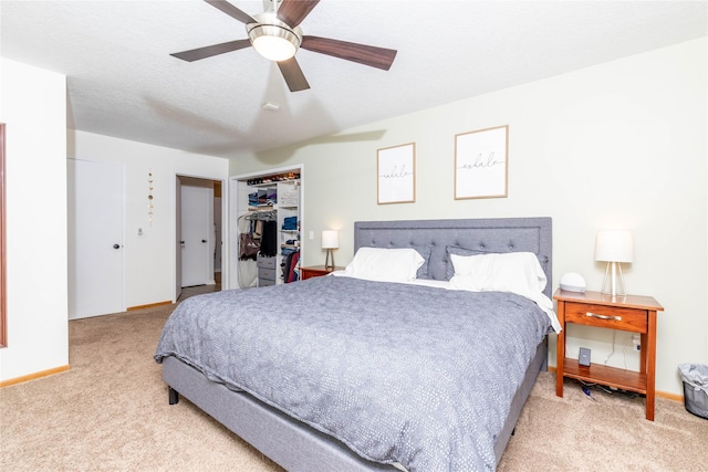 bedroom with ceiling fan, a textured ceiling, carpet floors, baseboards, and a closet