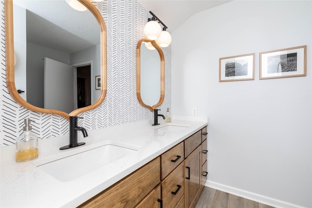 full bath featuring double vanity, backsplash, a sink, and wood finished floors