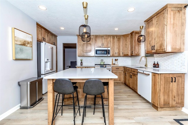 kitchen featuring tasteful backsplash, high quality appliances, a breakfast bar area, and a sink