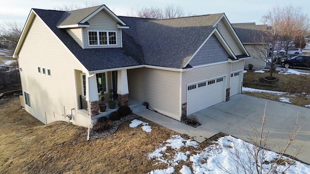 view of front of house with a garage, driveway, a shingled roof, and stone siding