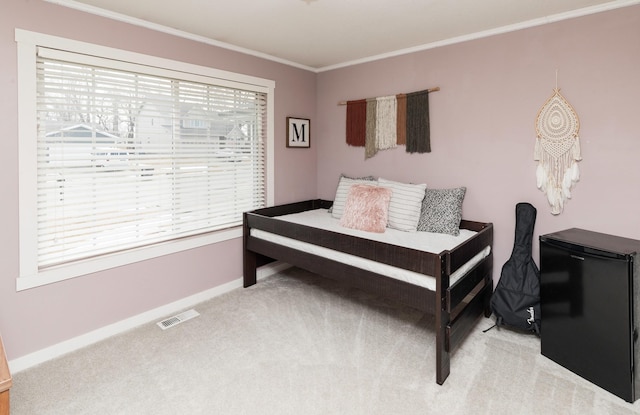 bedroom featuring multiple windows, visible vents, crown molding, and light colored carpet