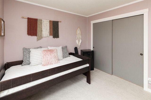 bedroom featuring ornamental molding, a closet, and carpet flooring