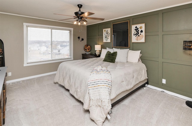 bedroom with a decorative wall, light carpet, visible vents, baseboards, and ornamental molding