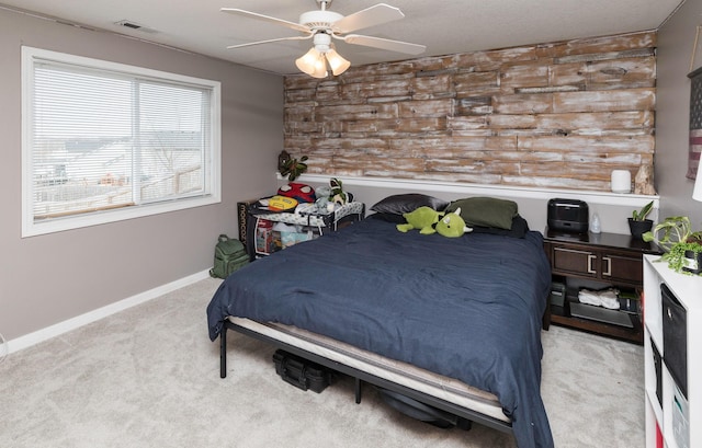 carpeted bedroom featuring baseboards, visible vents, and ceiling fan