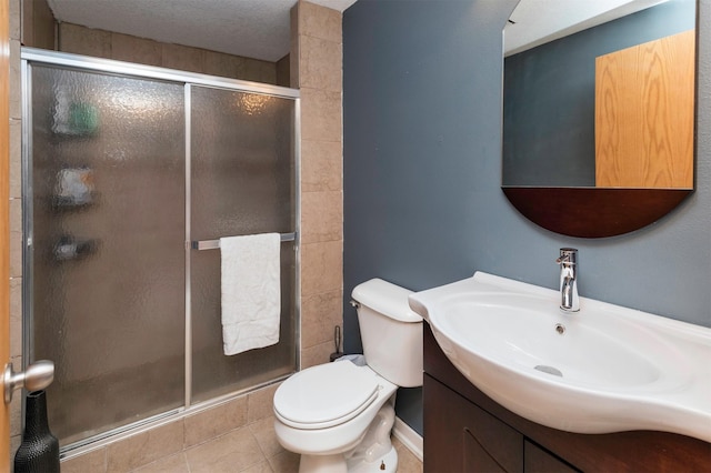 full bathroom featuring vanity, tile patterned flooring, toilet, and a shower stall