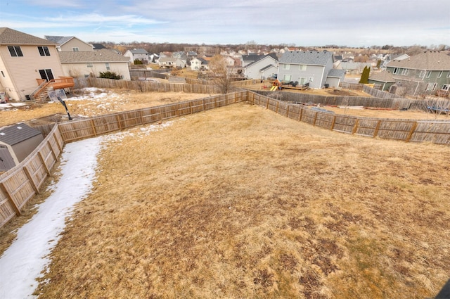 view of yard featuring a fenced backyard and a residential view