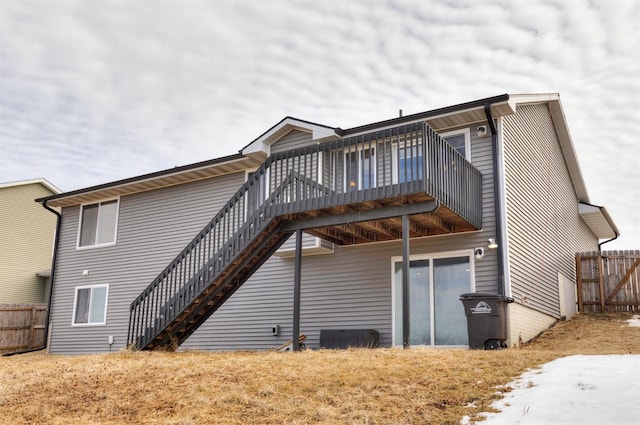 back of property with fence, stairway, and a wooden deck