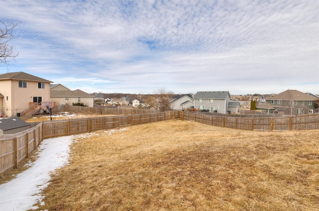 view of yard featuring a fenced backyard and a residential view