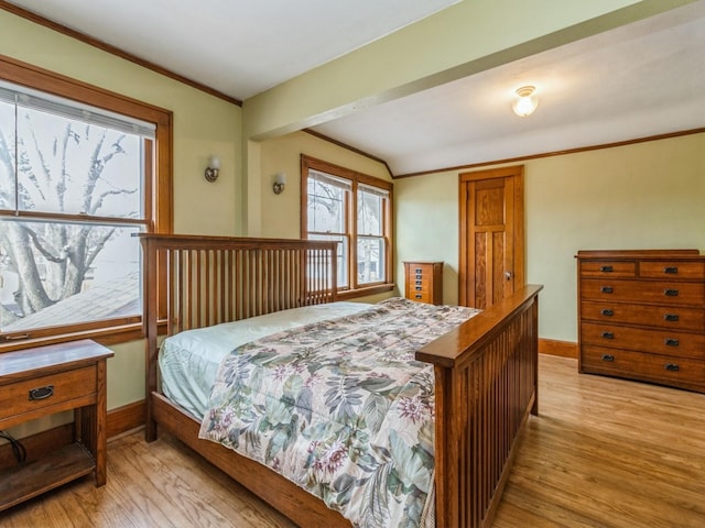 bedroom featuring crown molding, light wood finished floors, and baseboards