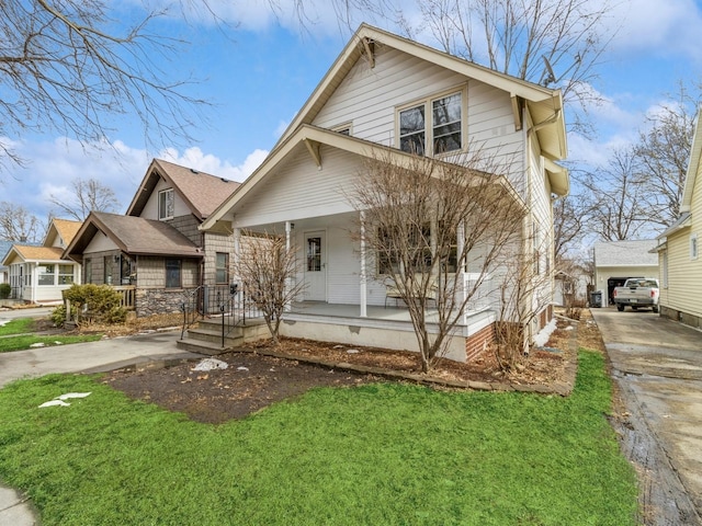 american foursquare style home featuring a porch and a front yard