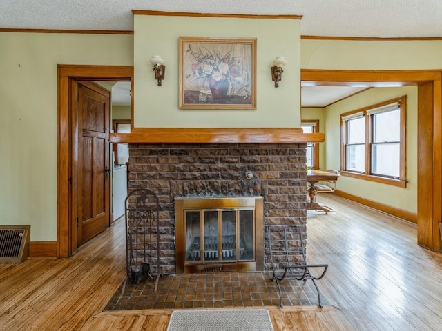 room details featuring a textured ceiling, visible vents, crown molding, and wood finished floors