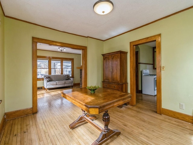 corridor featuring ornamental molding, light wood finished floors, a textured ceiling, and baseboards