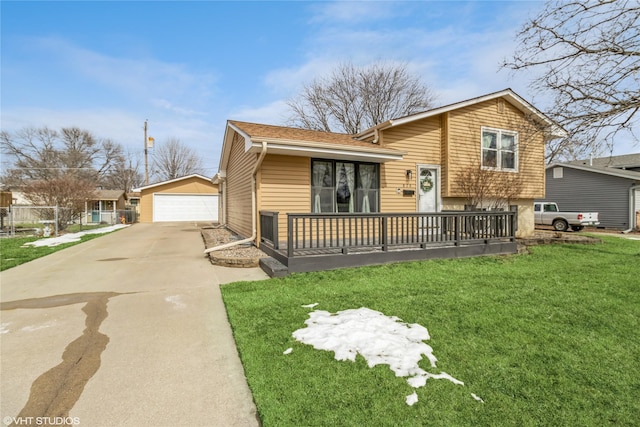 tri-level home with a garage, roof with shingles, a front lawn, and an outbuilding