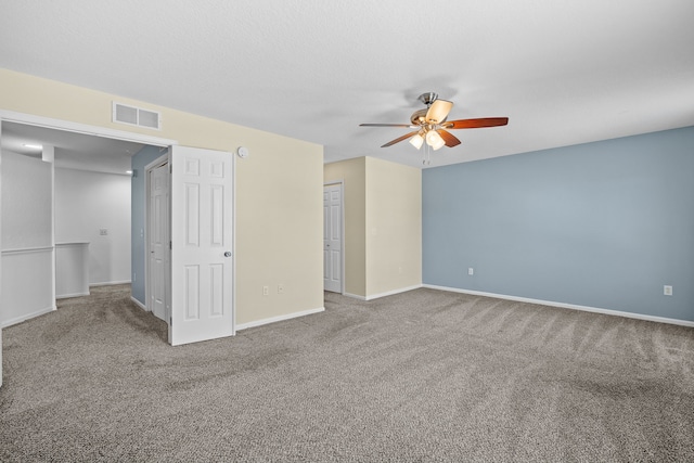 unfurnished bedroom featuring carpet, visible vents, a textured ceiling, and baseboards