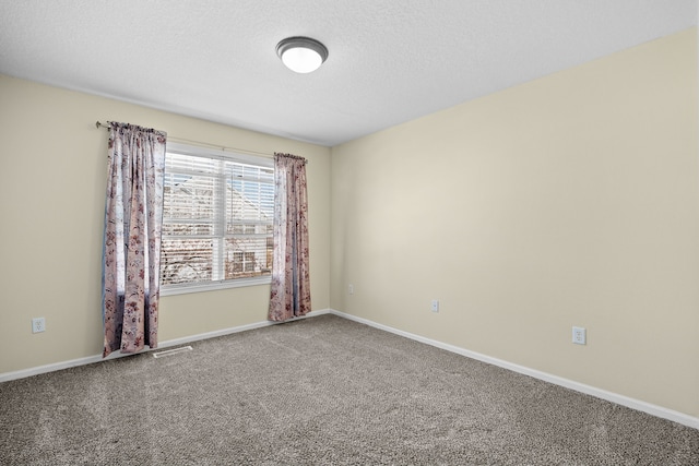 unfurnished room featuring carpet, visible vents, a textured ceiling, and baseboards