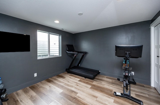 workout room with light wood finished floors, recessed lighting, and baseboards