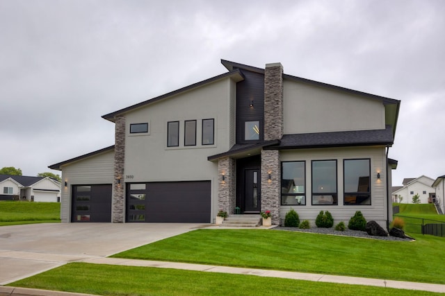 modern home featuring an attached garage, stone siding, driveway, stucco siding, and a front lawn