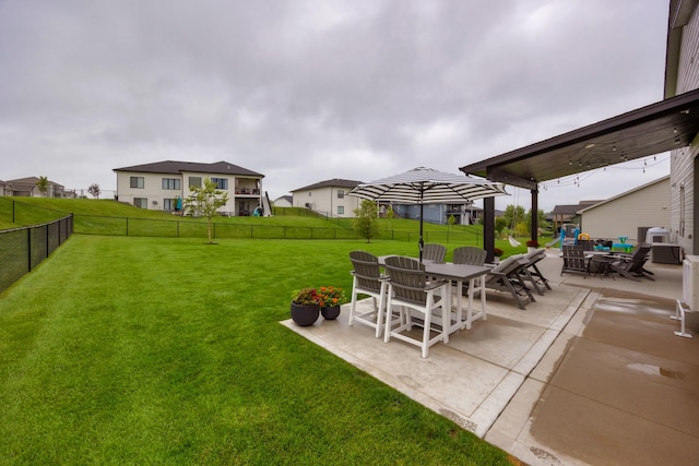 view of yard featuring outdoor dining space, a patio area, and a fenced backyard