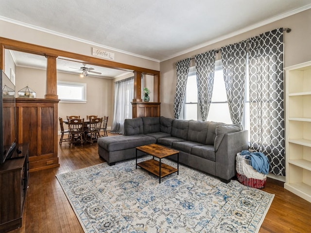 living room with ornamental molding, dark wood-style flooring, a ceiling fan, and ornate columns