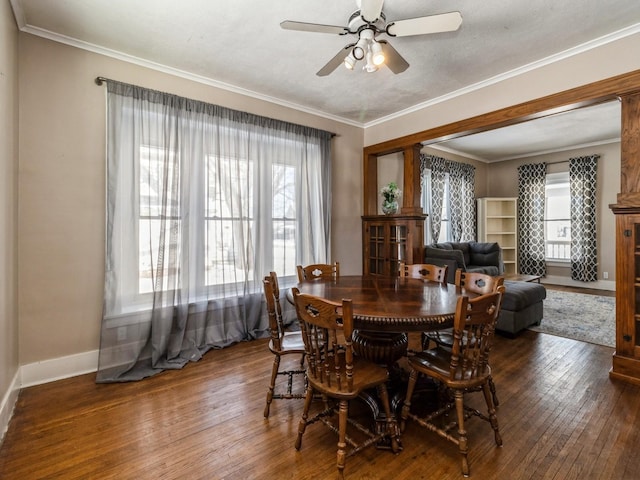 dining area with a ceiling fan, baseboards, ornamental molding, and dark wood-style flooring