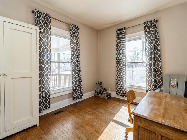 office with hardwood / wood-style flooring, visible vents, and baseboards