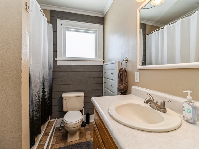 bathroom featuring a shower with shower curtain, toilet, stone finish floor, crown molding, and vanity