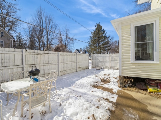 snowy yard with a fenced backyard