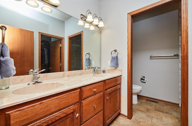 full bathroom featuring double vanity, visible vents, stone finish floor, a sink, and baseboards