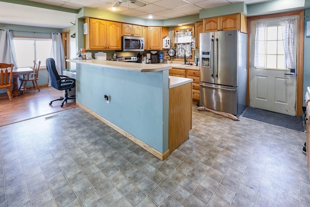 kitchen featuring visible vents, a sink, stainless steel appliances, light countertops, and a paneled ceiling