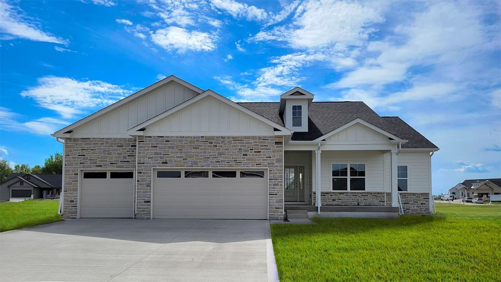 650 NW Concord Ln, Waukee, IA 50263 - craftsman house featuring stone siding, board and batten siding, driveway, a front yard, and an attached garage