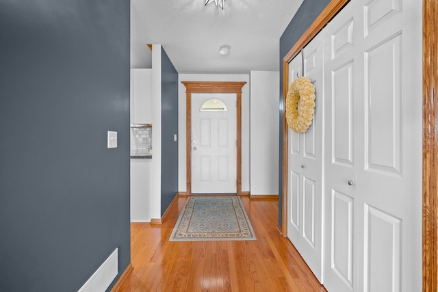 doorway to outside featuring light wood-type flooring and baseboards