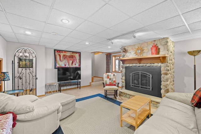 living area featuring baseboards, a drop ceiling, rail lighting, a fireplace, and recessed lighting