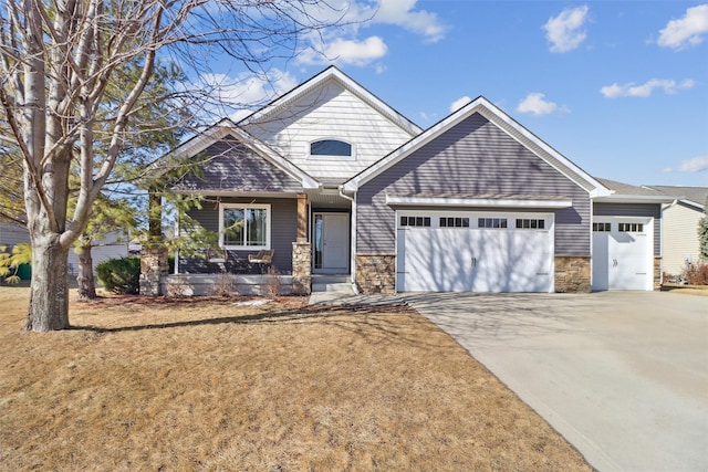 view of front of house with an attached garage, stone siding, and concrete driveway