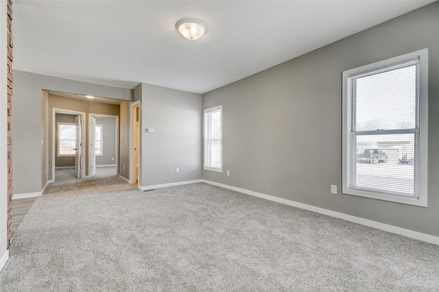 carpeted empty room featuring baseboards and a healthy amount of sunlight