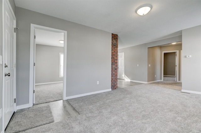 carpeted spare room with baseboards and wood finished floors