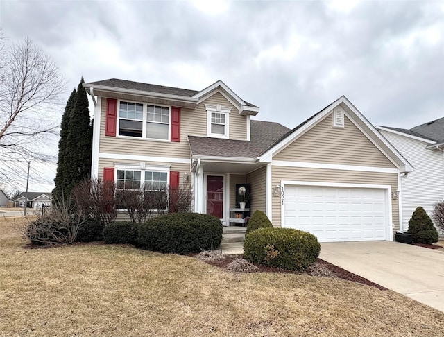 traditional-style home with a garage, driveway, a shingled roof, and a front yard