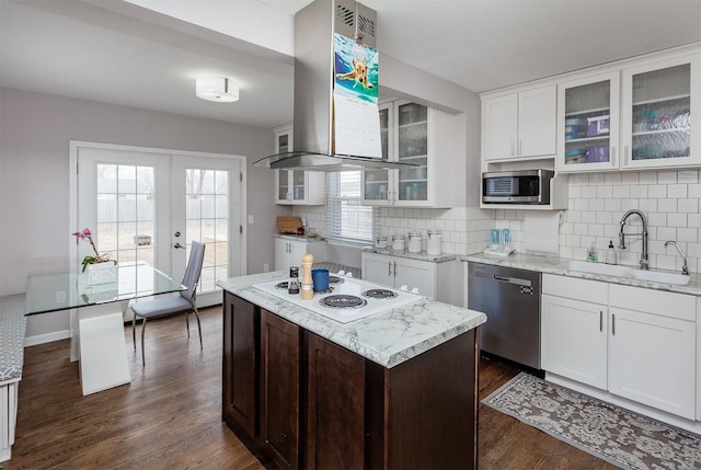 kitchen featuring white cabinets, dark wood finished floors, wall chimney exhaust hood, stainless steel appliances, and a sink